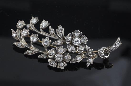 An early 20th century gold, silver and diamond set floral spray brooch, 60mm.